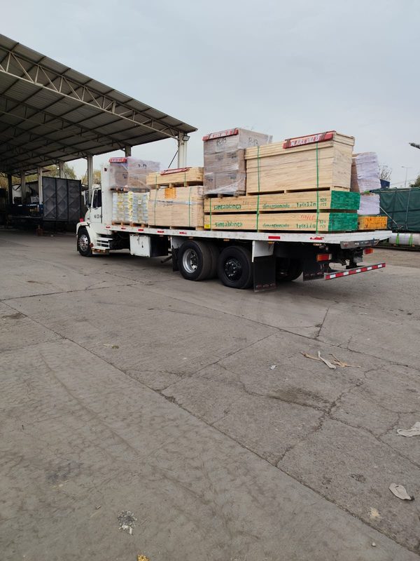 Camión plataforma de RutaFirme cargado con materiales de construcción en Santiago